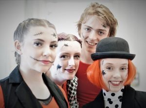 Students in make up posing for a photo before their annual dance show