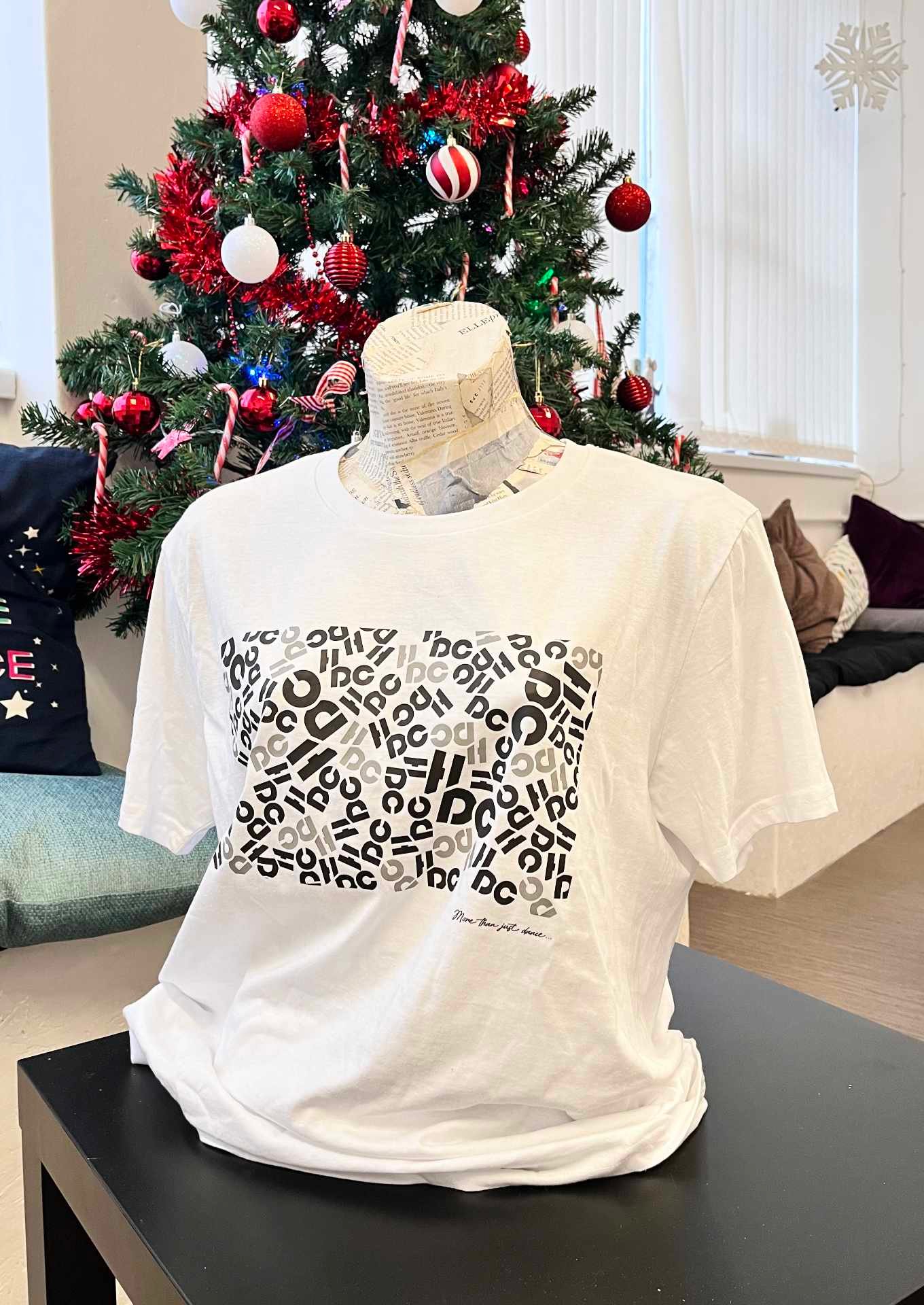 A Hype dance branded tee hoodie in front of a Christmas tree